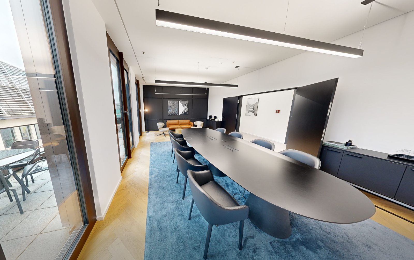 Club Room, 8-seat oval boardroom table on Floor 6, daylight through floor-to-ceiling windows.